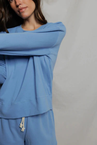 Person wearing a blue tracksuit against a plain background