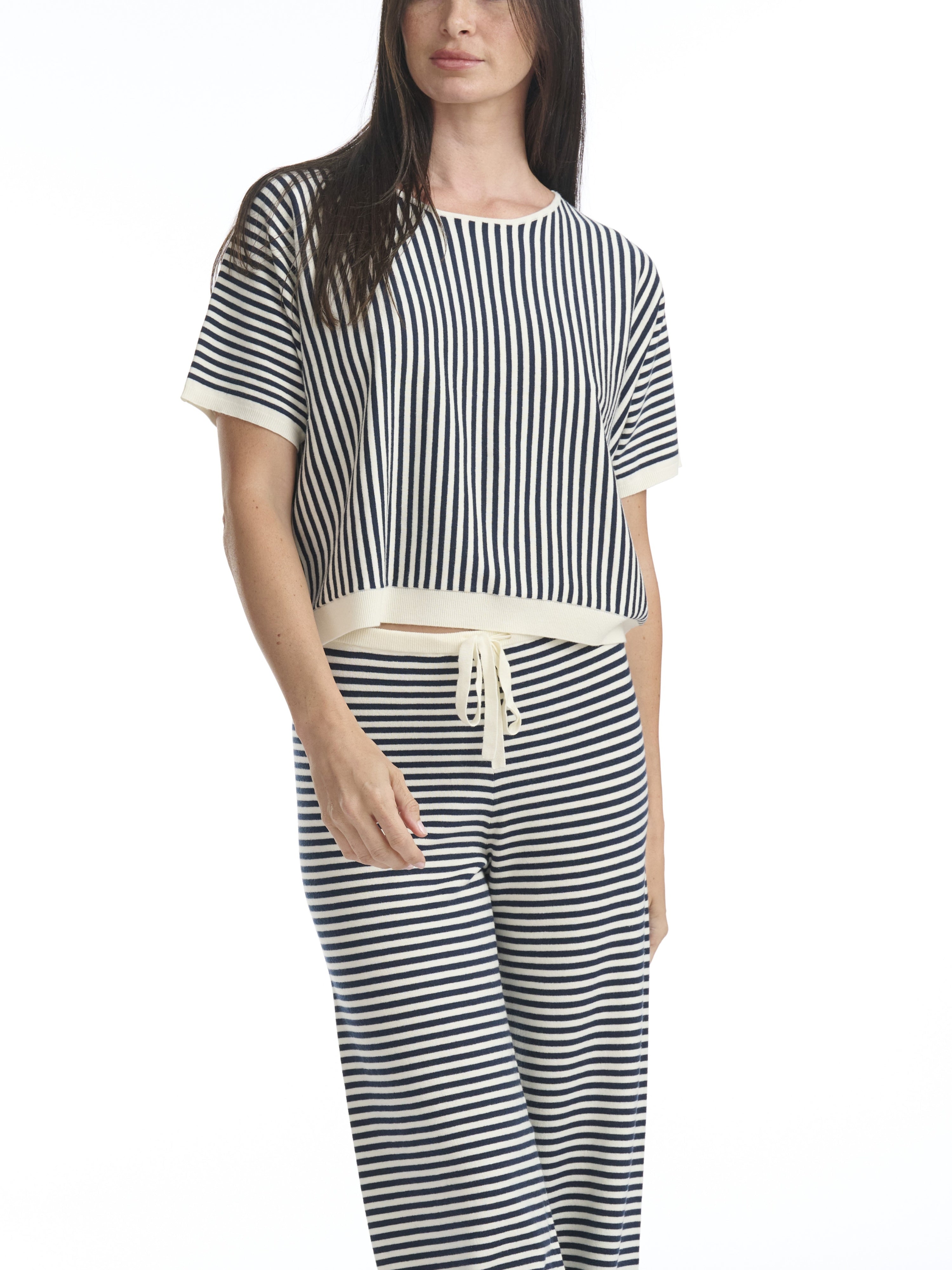Woman wearing a black and white striped outfit on a white background