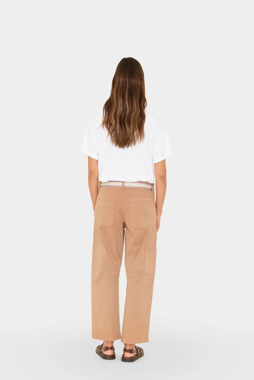 Person wearing a white shirt and beige pants on a white background