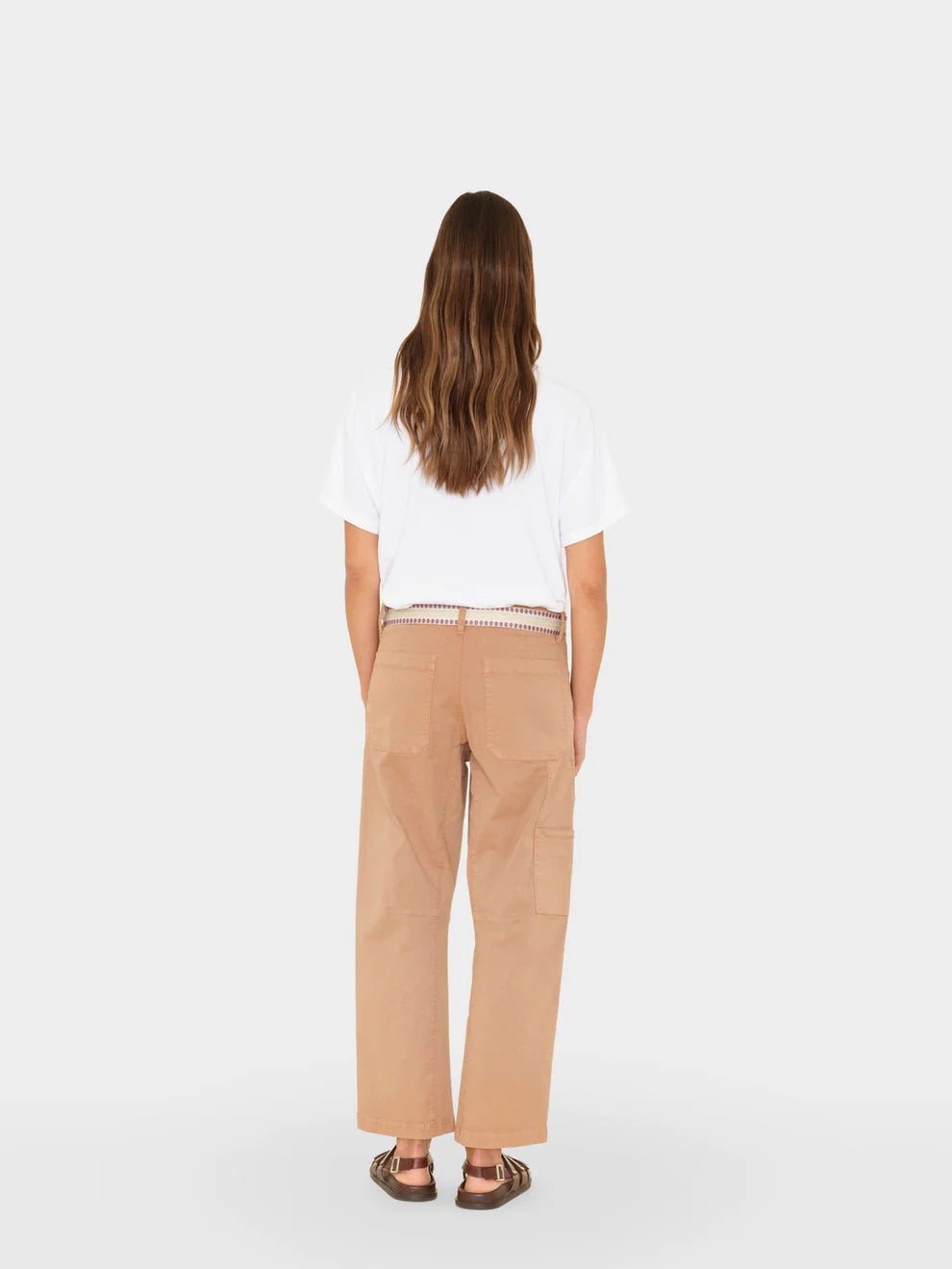 Person wearing a white shirt and beige pants on a white background