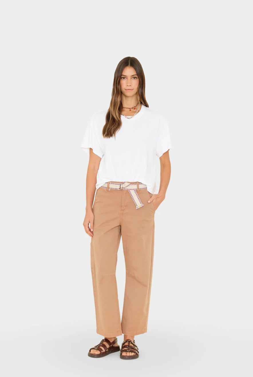 Woman wearing a white top and beige pants on a white background
