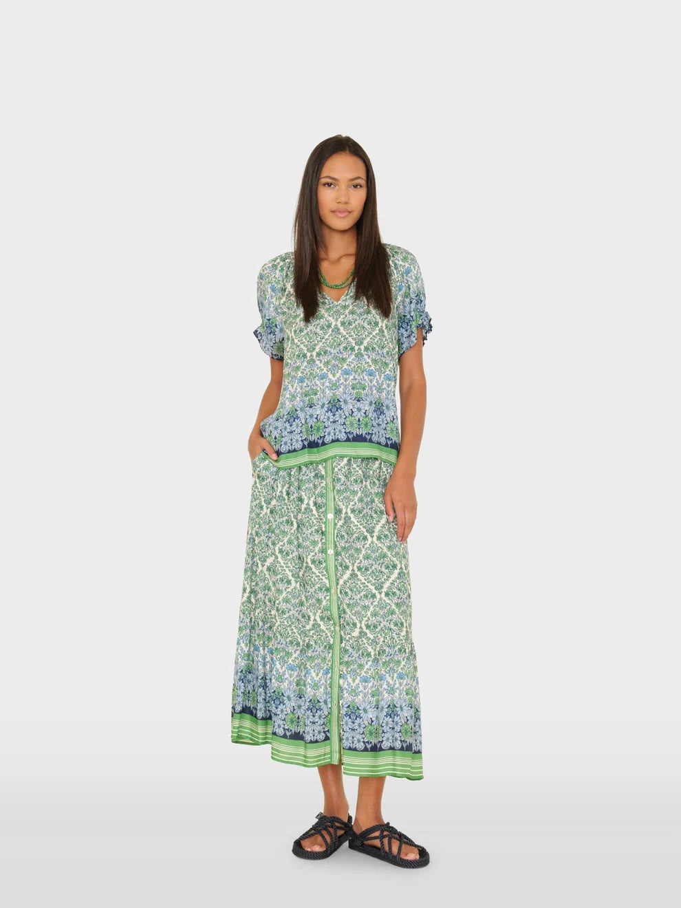 Woman wearing a patterned outfit on a white background