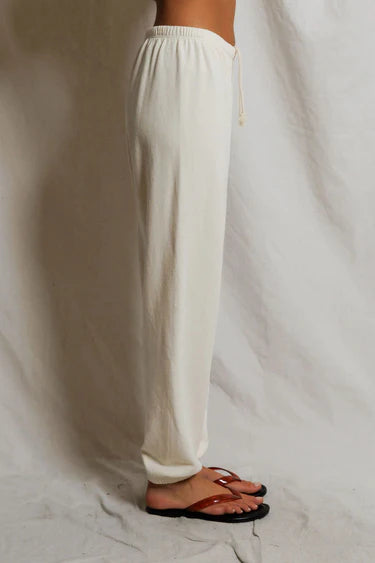 White pants worn by a person on a plain background