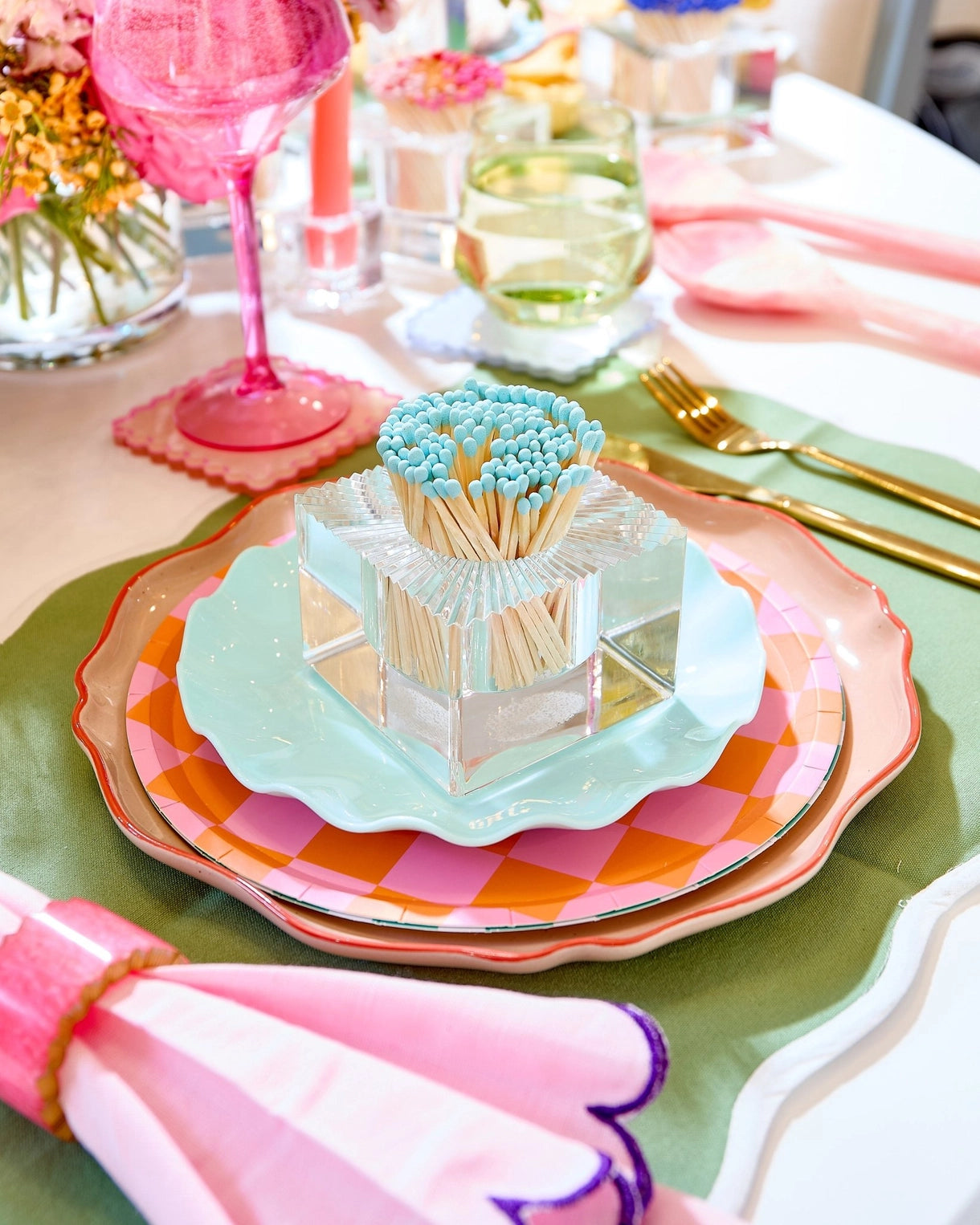 Colorful table setting with plates, napkins, and decorative items on a table.