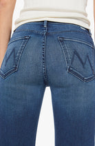 Close-up of blue jeans with a brand logo on a white background