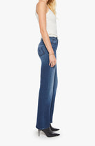 Woman wearing blue jeans and a white top on a white background