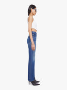 Woman wearing blue jeans and a white top on a white background