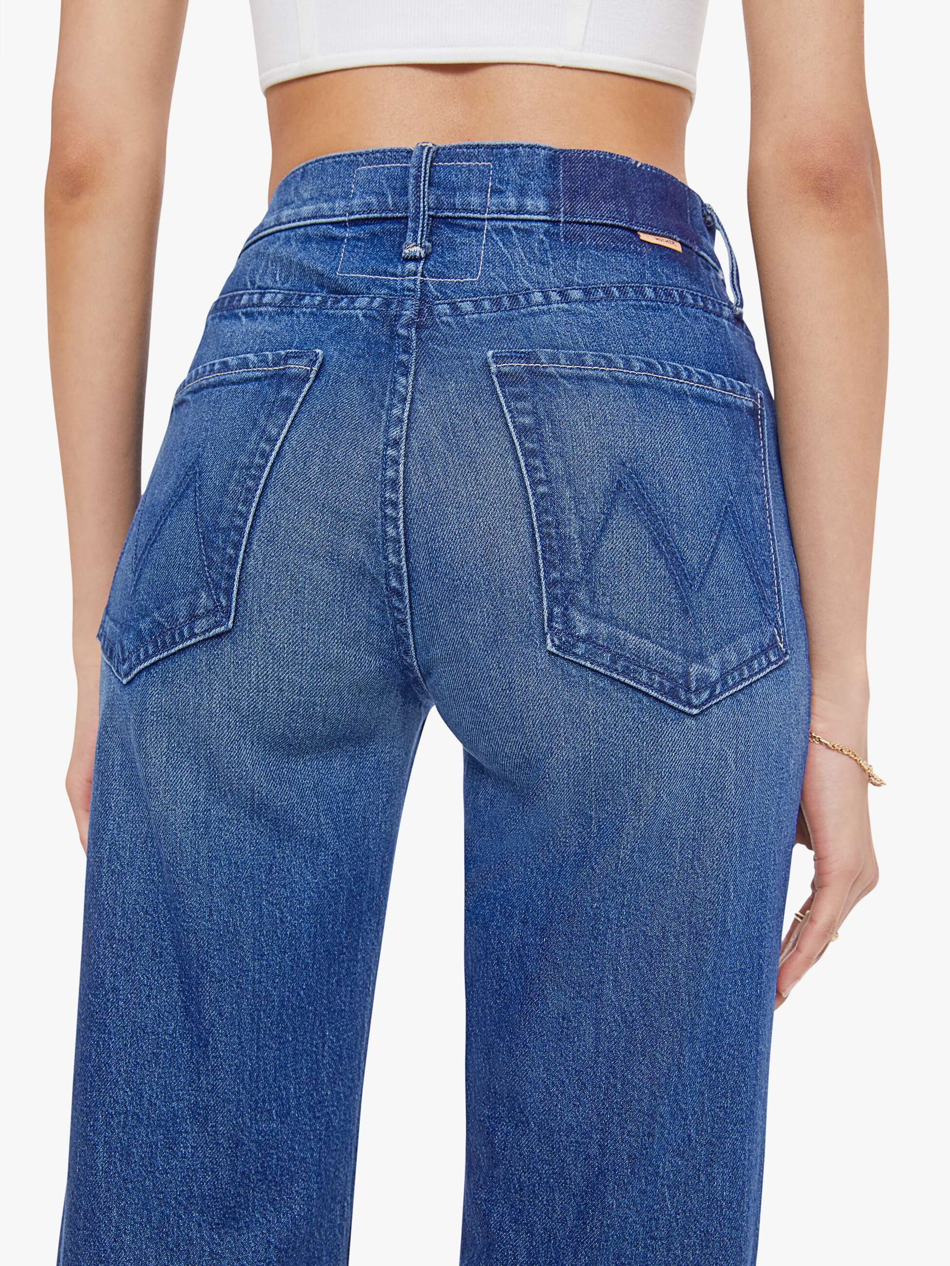 Blue jeans worn by a person on a white background