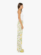 Woman wearing a white top and floral pants on a white background
