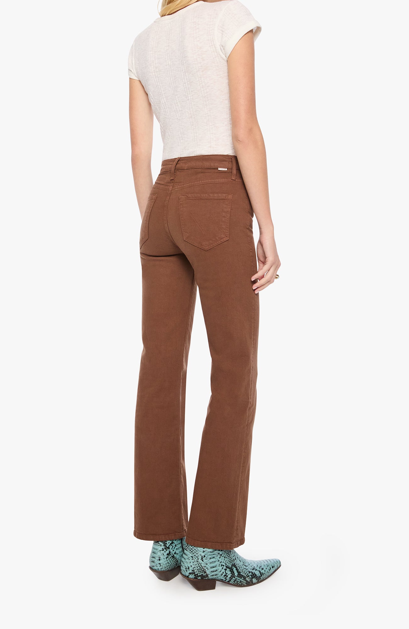 A model shown from the back wearing brown high-waisted straight-leg jeans, a cream short-sleeve top, and green patterned cowboy boots against a plain white background.