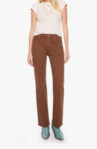 A model wearing brown straight-leg corduroy pants, a light beige short-sleeve top, and green snakeskin-patterned shoes, standing against a plain white background.