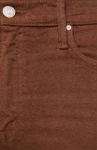 Close-up of brown denim pants showing the waistband, button, rivet, and front pocket stitching.