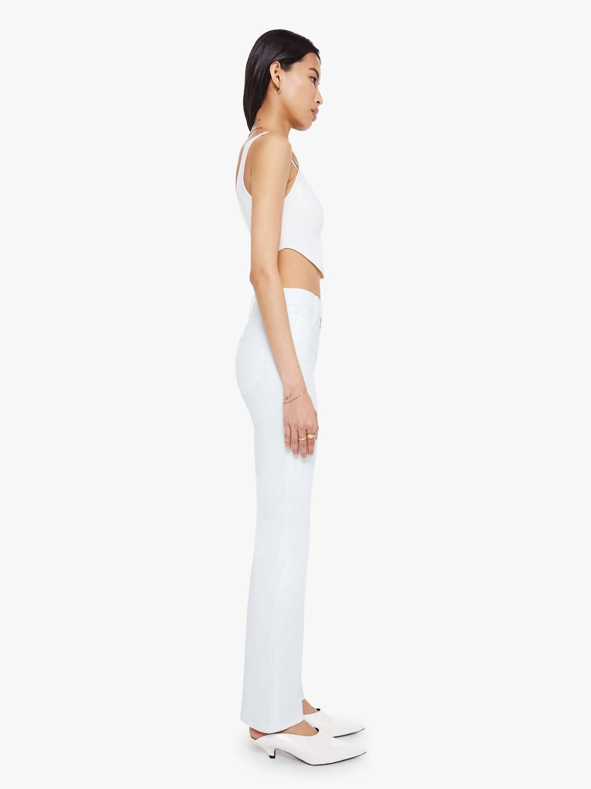 Woman wearing a white sleeveless top and pants on a white background