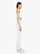 Woman wearing a white sleeveless top and pants on a white background