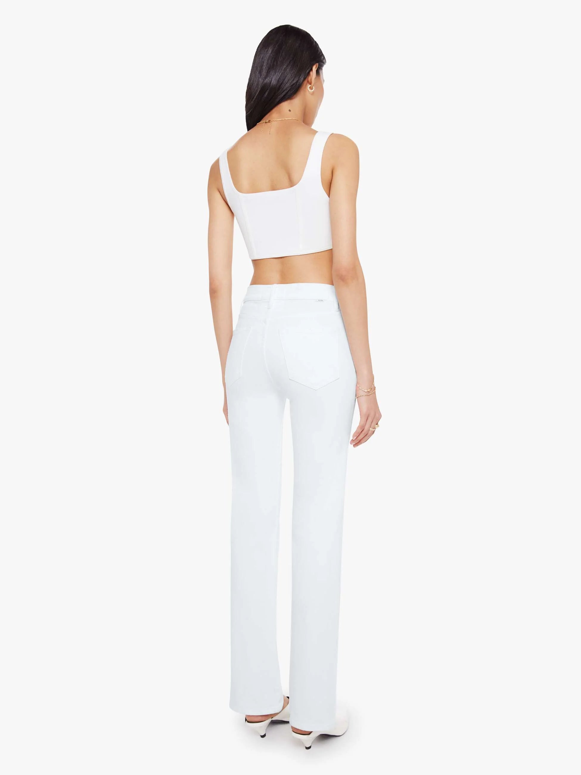 Woman wearing a white sleeveless top and pants on a white background