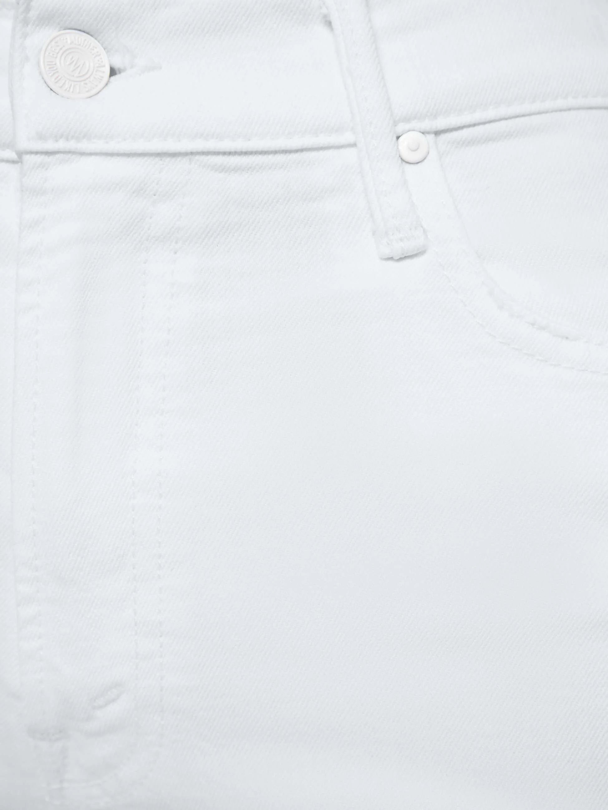 Close-up of white denim fabric with button details