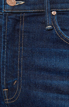 Close-up of dark blue denim jeans showing the front pocket, stitching, rivet, and copper-toned metal hardware.