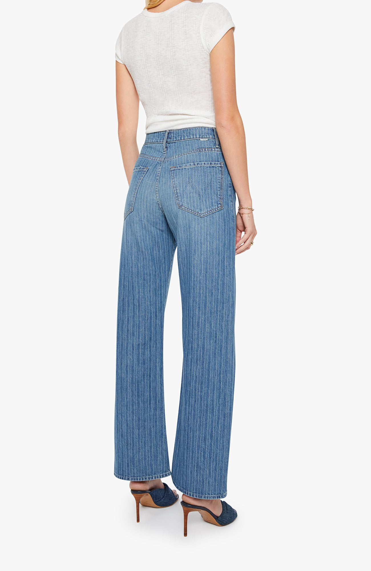 Woman wearing a white top and blue jeans on a white background