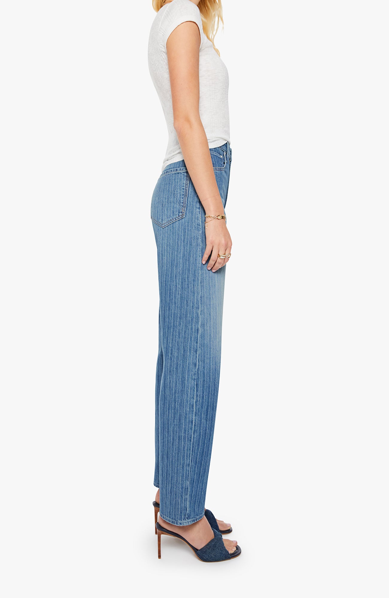 Woman wearing a white top and blue jeans on a white background