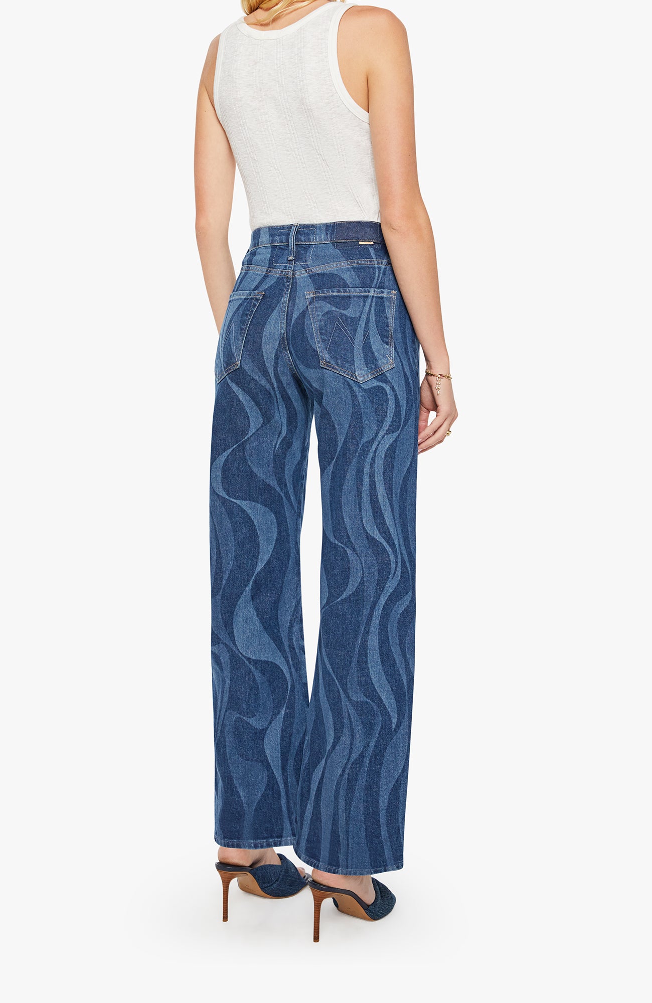 Woman wearing blue patterned jeans on a white background
