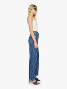 Woman wearing blue jeans and a white top on a white background