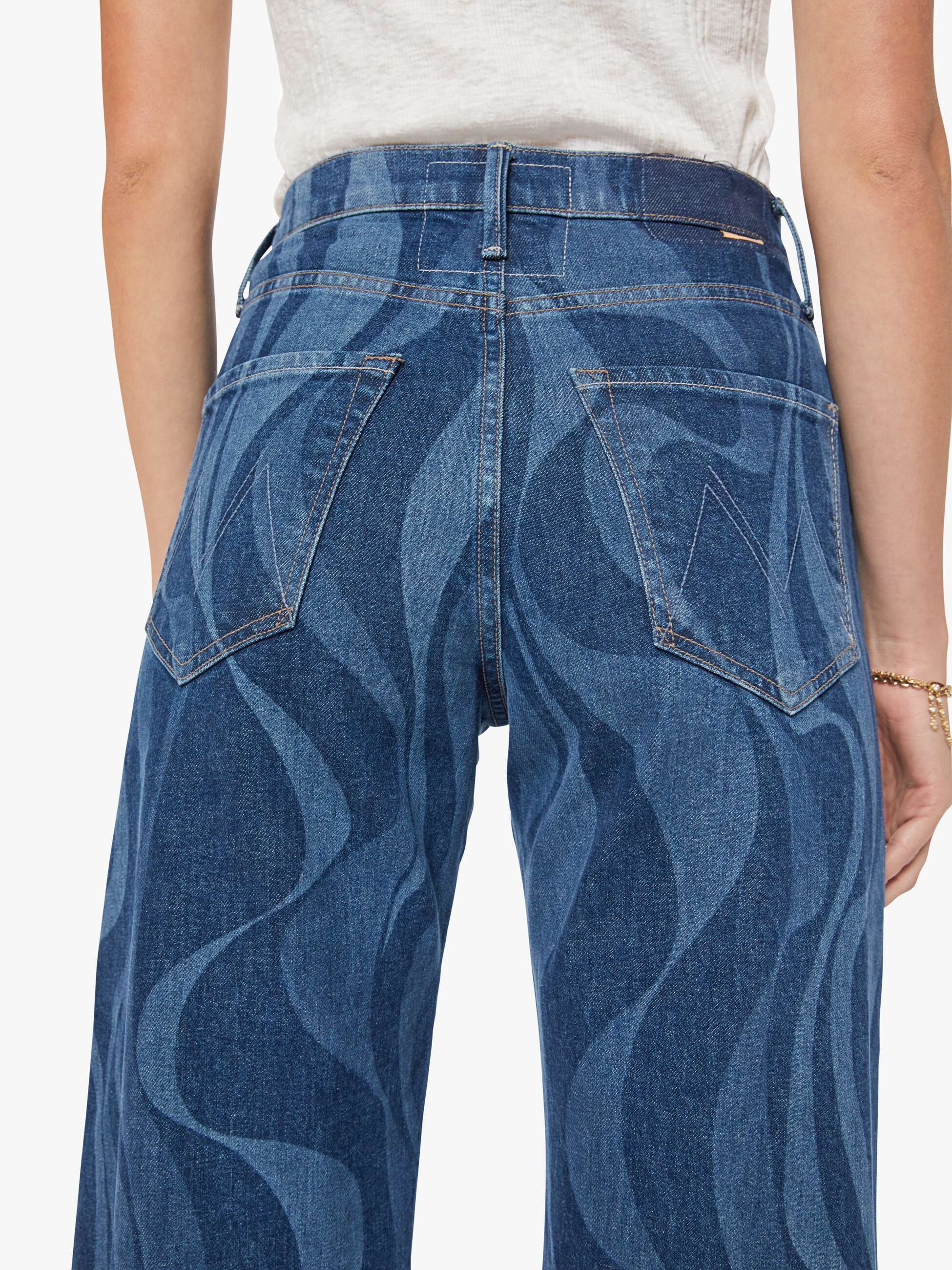 Blue jeans with wavy pattern worn by a person on a white background