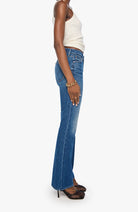 Person wearing blue jeans and a white top on a white background