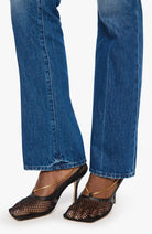 Blue jeans and black open-toe high-heeled shoes on a white background