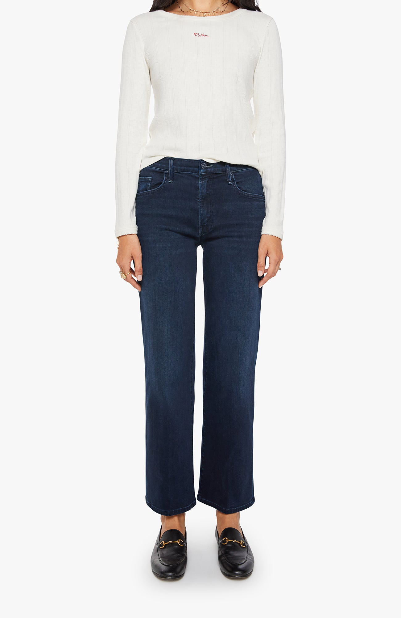 Person wearing a white long-sleeve shirt and dark blue jeans on a white background