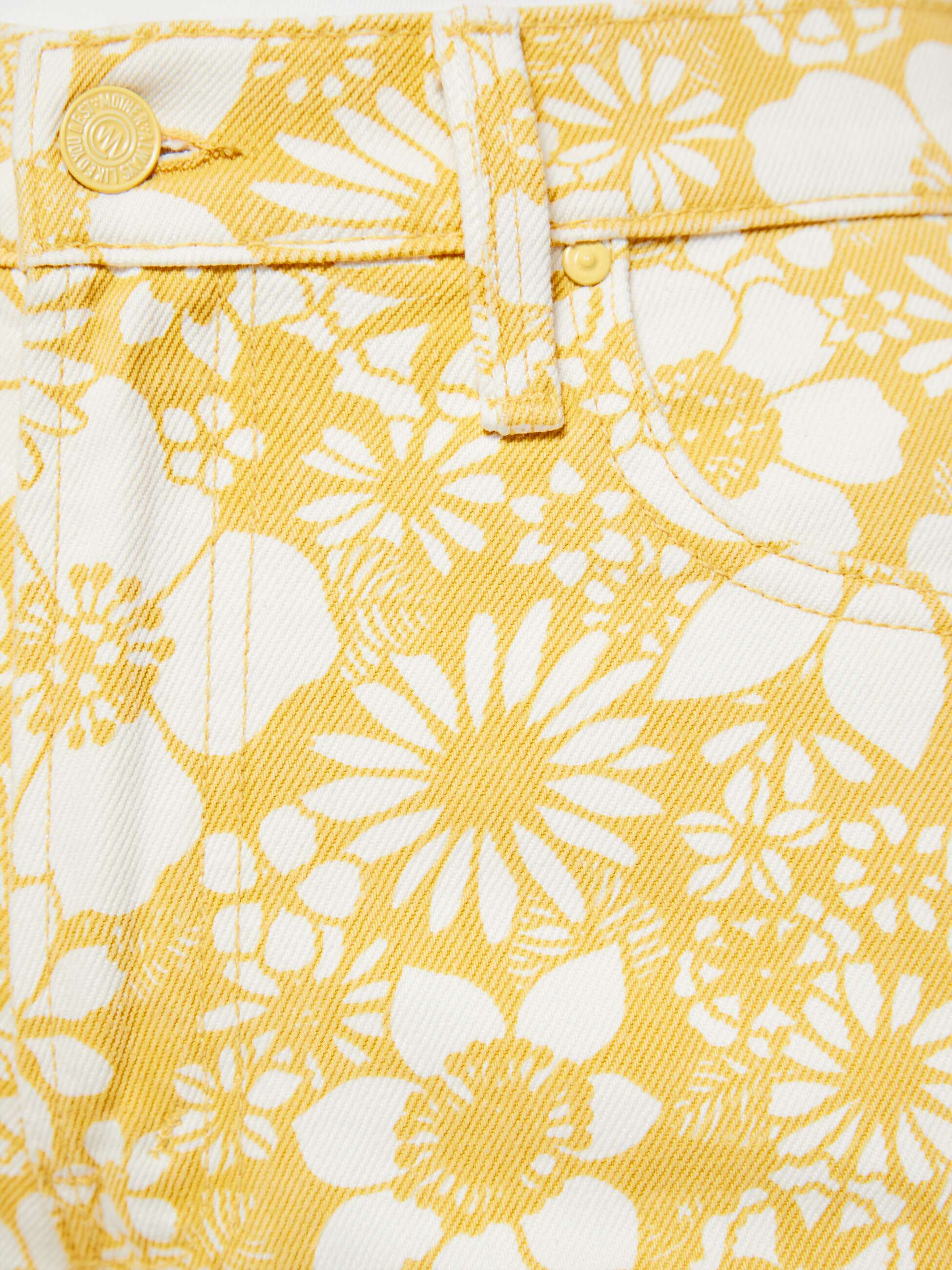 Close-up of yellow fabric with white floral pattern