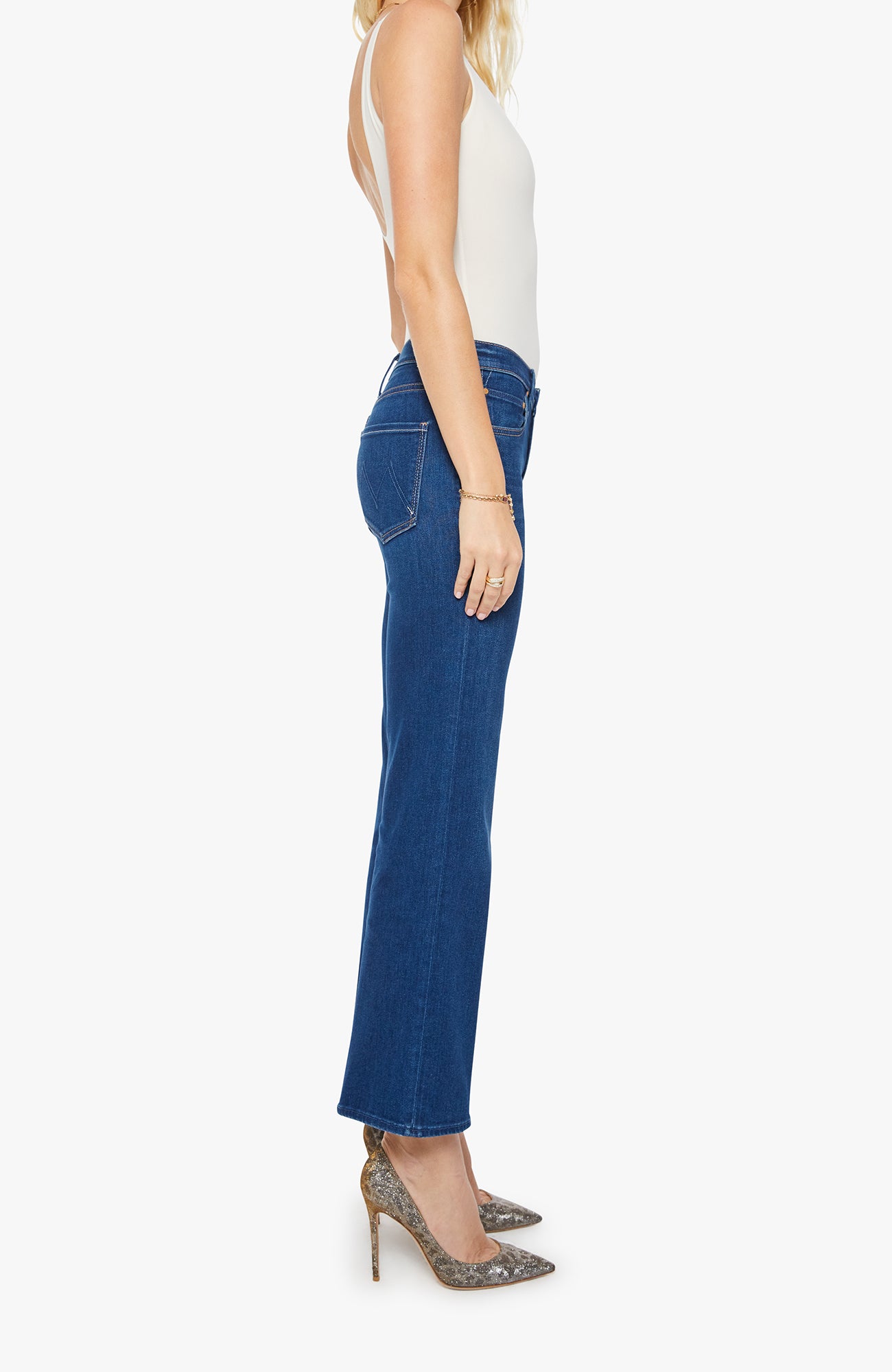 Woman wearing blue jeans and a white top on a white background