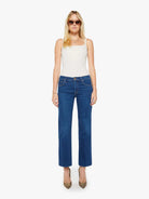 Woman wearing blue jeans and a white top on a white background