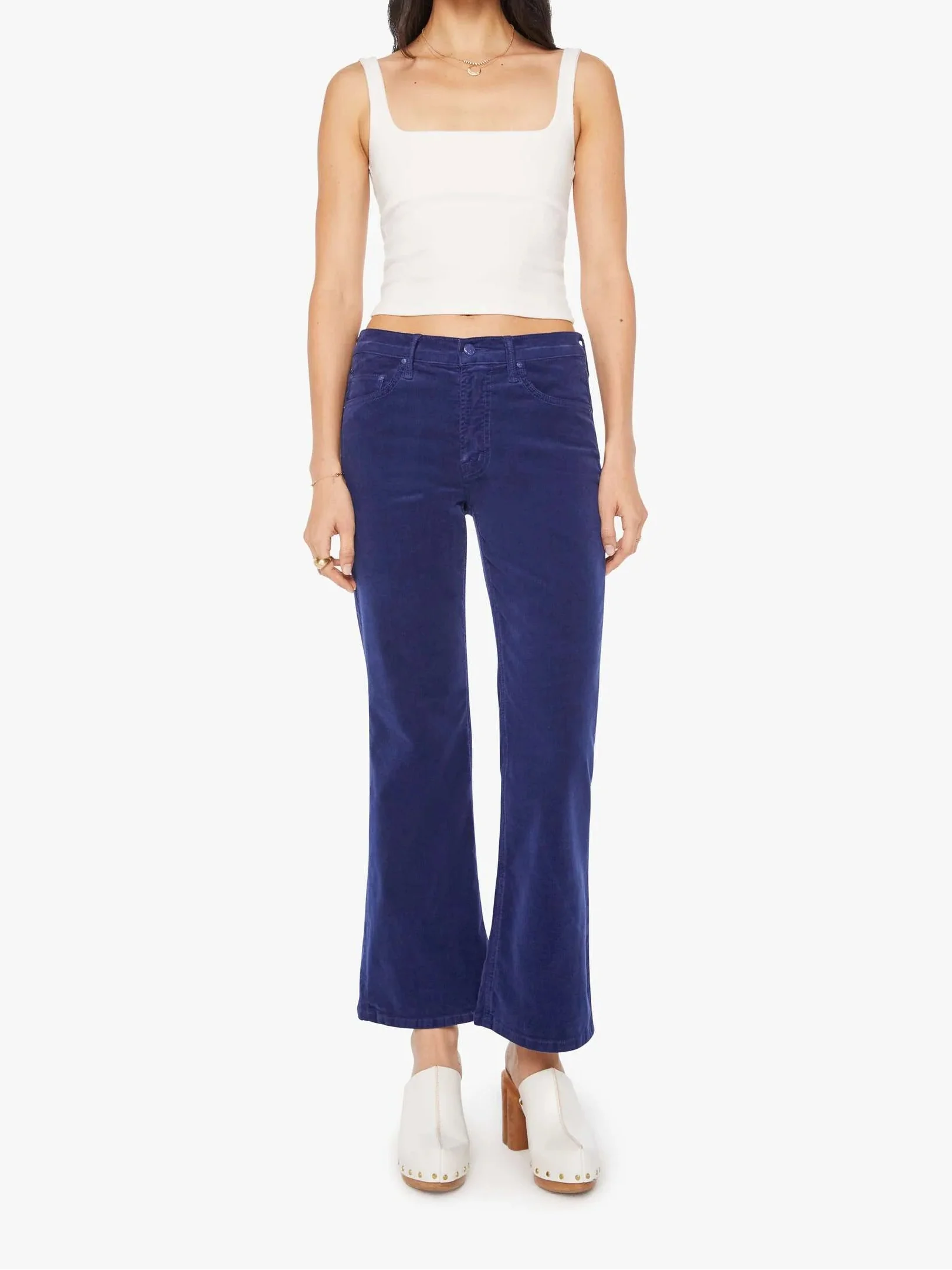 Woman wearing a white top and blue jeans on a white background