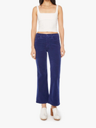 Woman wearing a white top and blue jeans on a white background