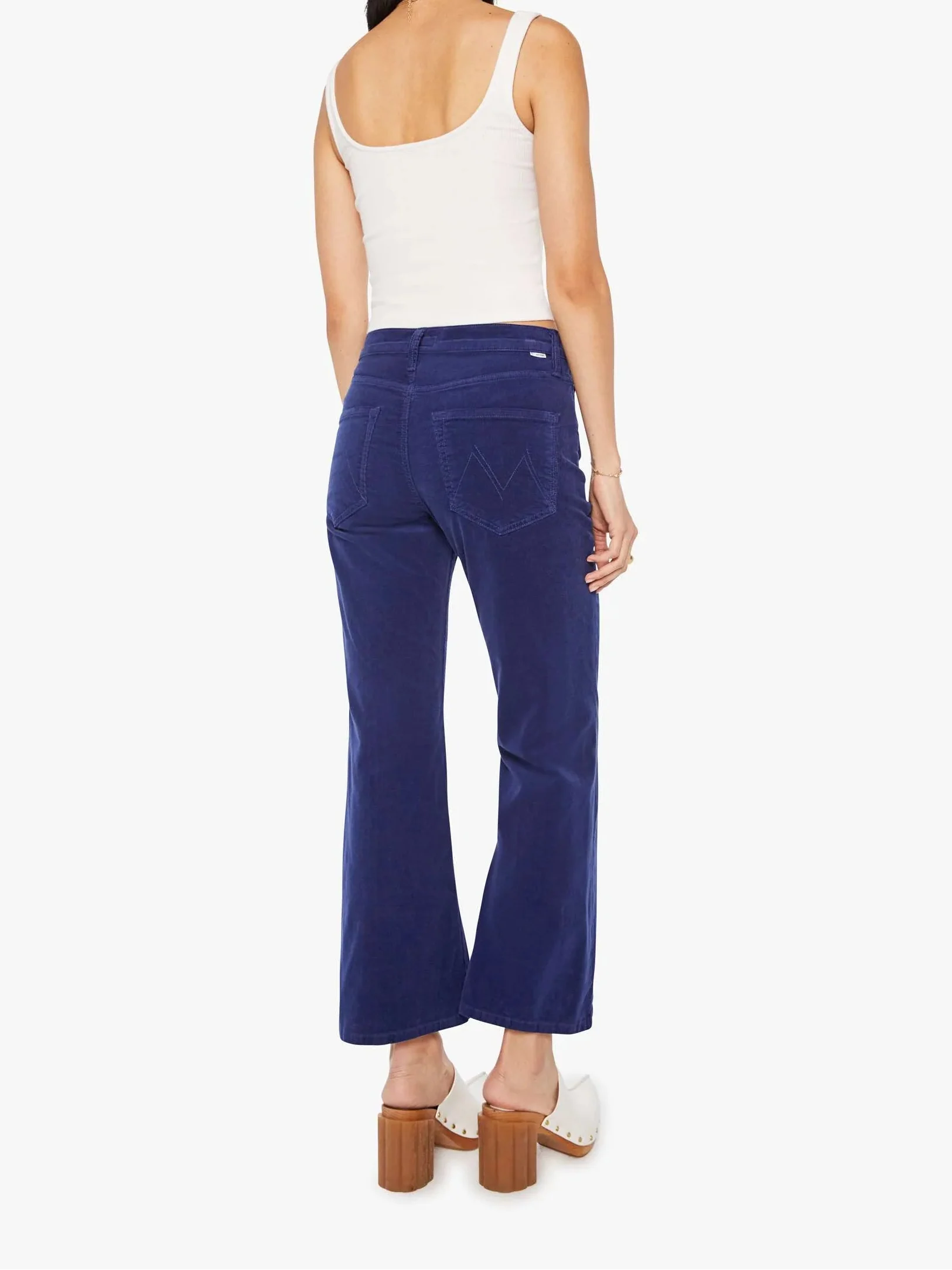 Woman wearing blue pants and a white top on a white background
