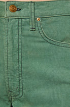 Close-up of a pair of green corduroy pants showing the waistband, belt loop, button, front pocket, and rivet.