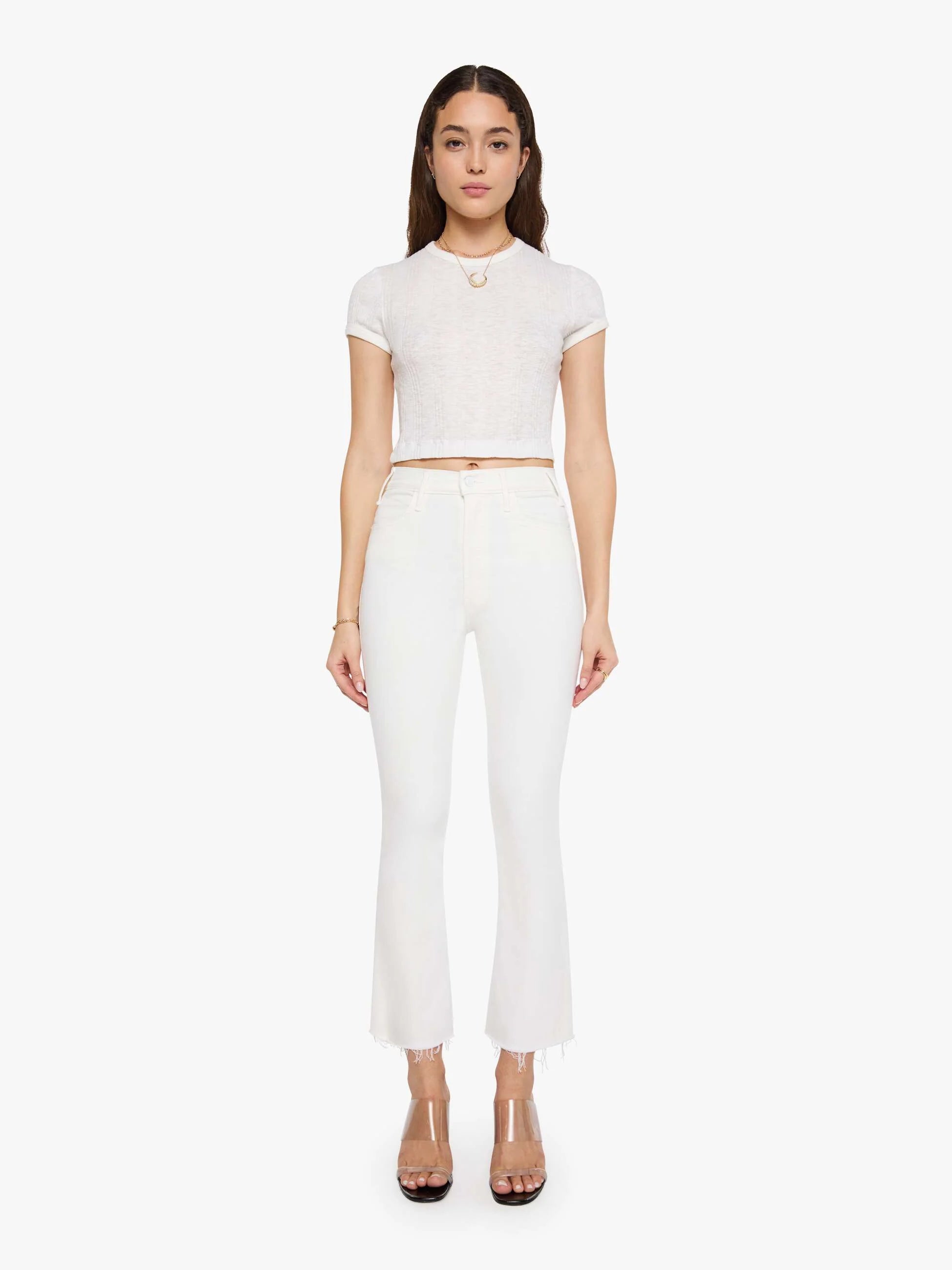 Woman wearing a white crop top and pants on a white background