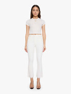 Woman wearing a white crop top and pants on a white background