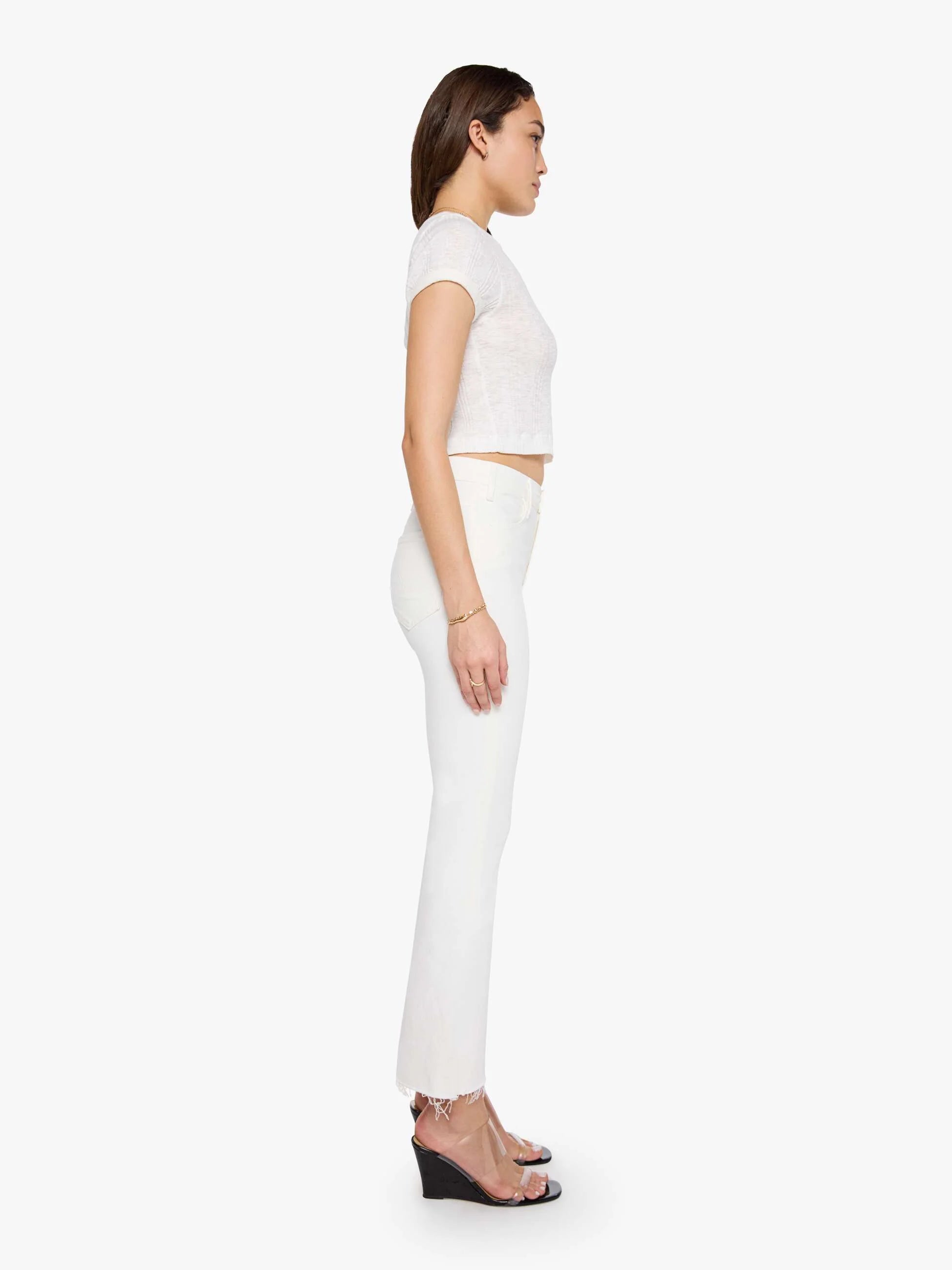 Woman wearing a white sleeveless top and pants on a white background