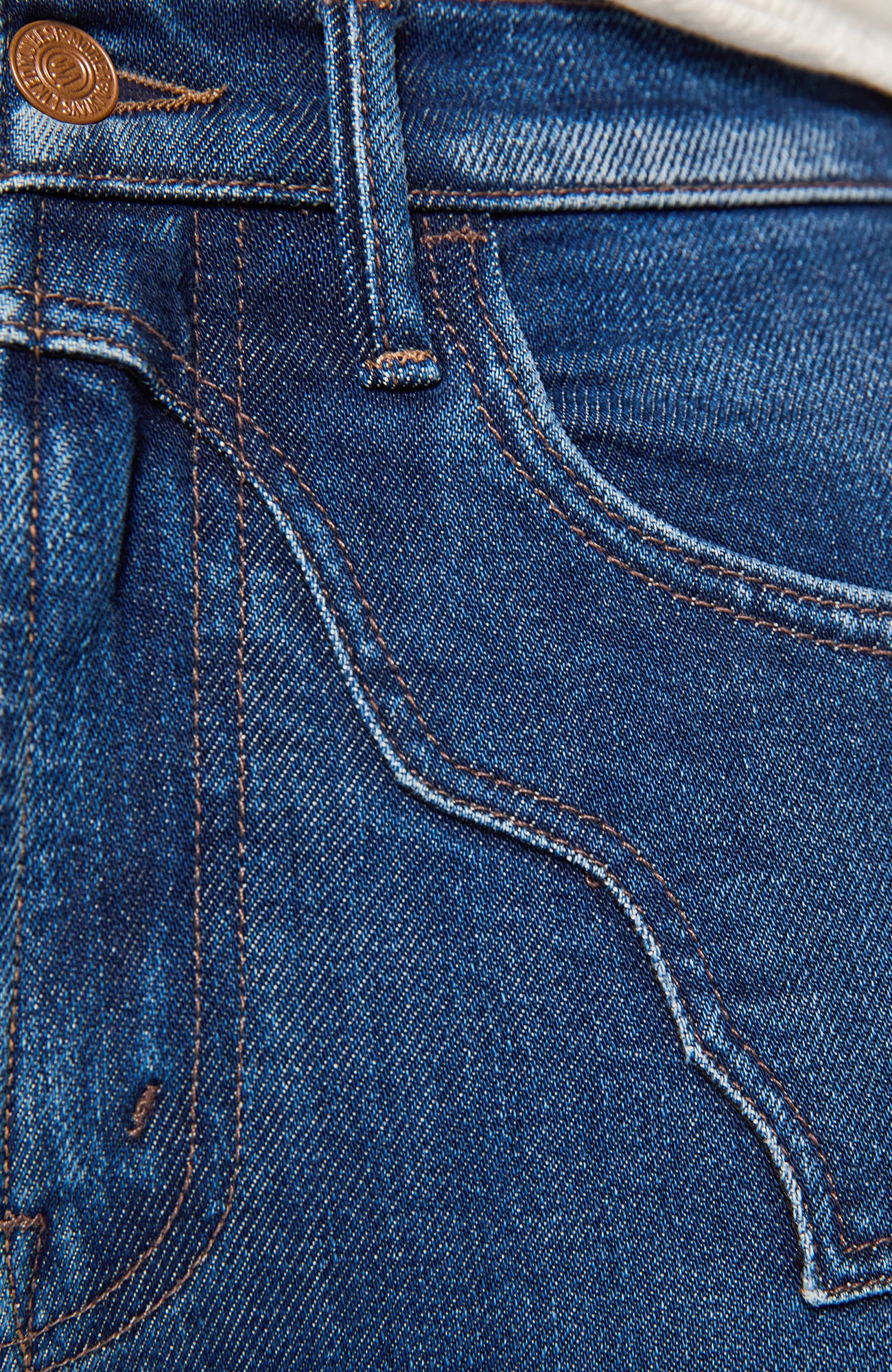 Close-up detail of blue denim jeans showing the waistband, belt loops, front pocket, and contrast stitching.