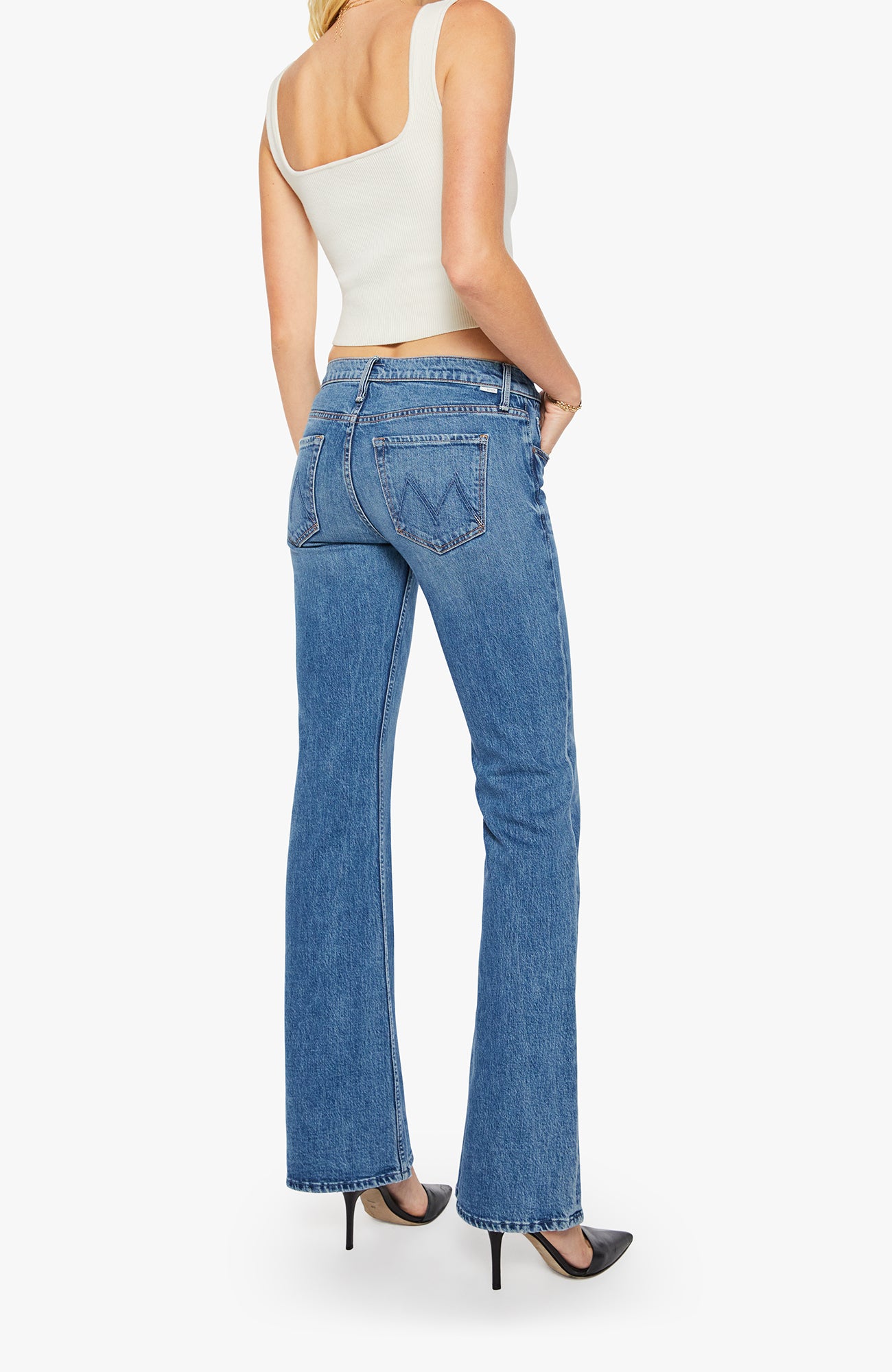 Person wearing blue jeans and a white top on a white background