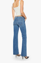 Person wearing blue jeans and a white top on a white background