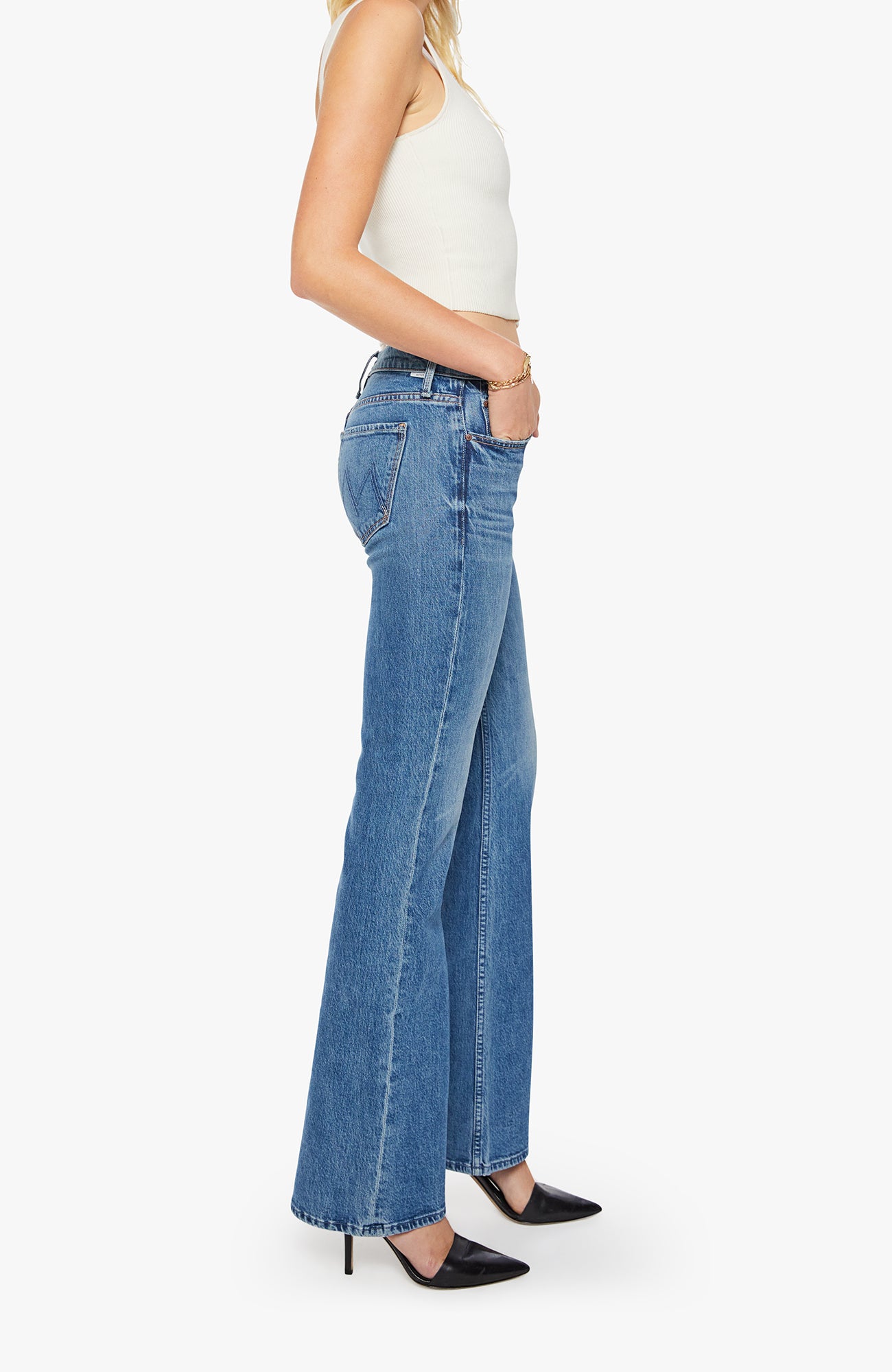 Person wearing blue flared jeans on a white background