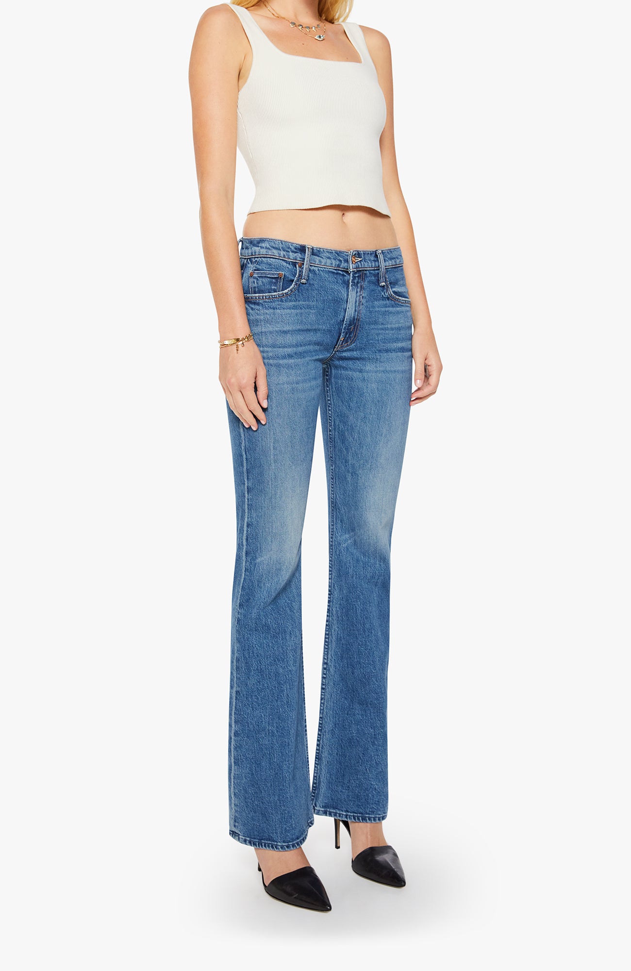 Person wearing a white tank top and blue jeans on a white background