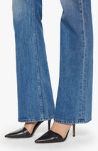 Blue jeans and black high-heeled shoes on a white background