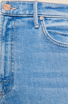 Close-up of light blue denim jeans showing the waistband, belt loops, button, front pocket, and stitching details.