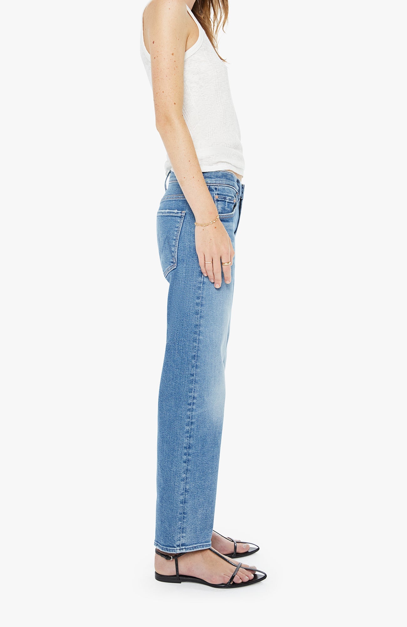 Person wearing light blue jeans and a white top on a white background