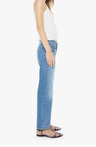 Person wearing light blue jeans and a white top on a white background