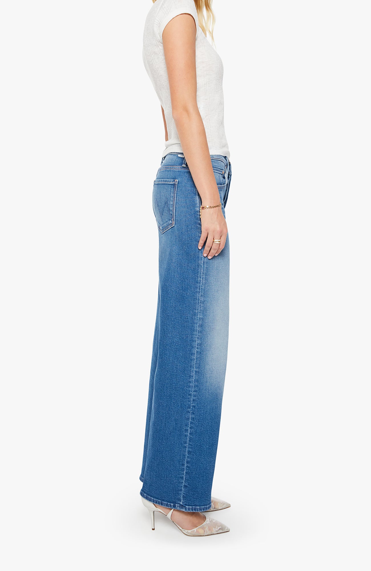 Woman wearing blue jeans and a white top on a white background