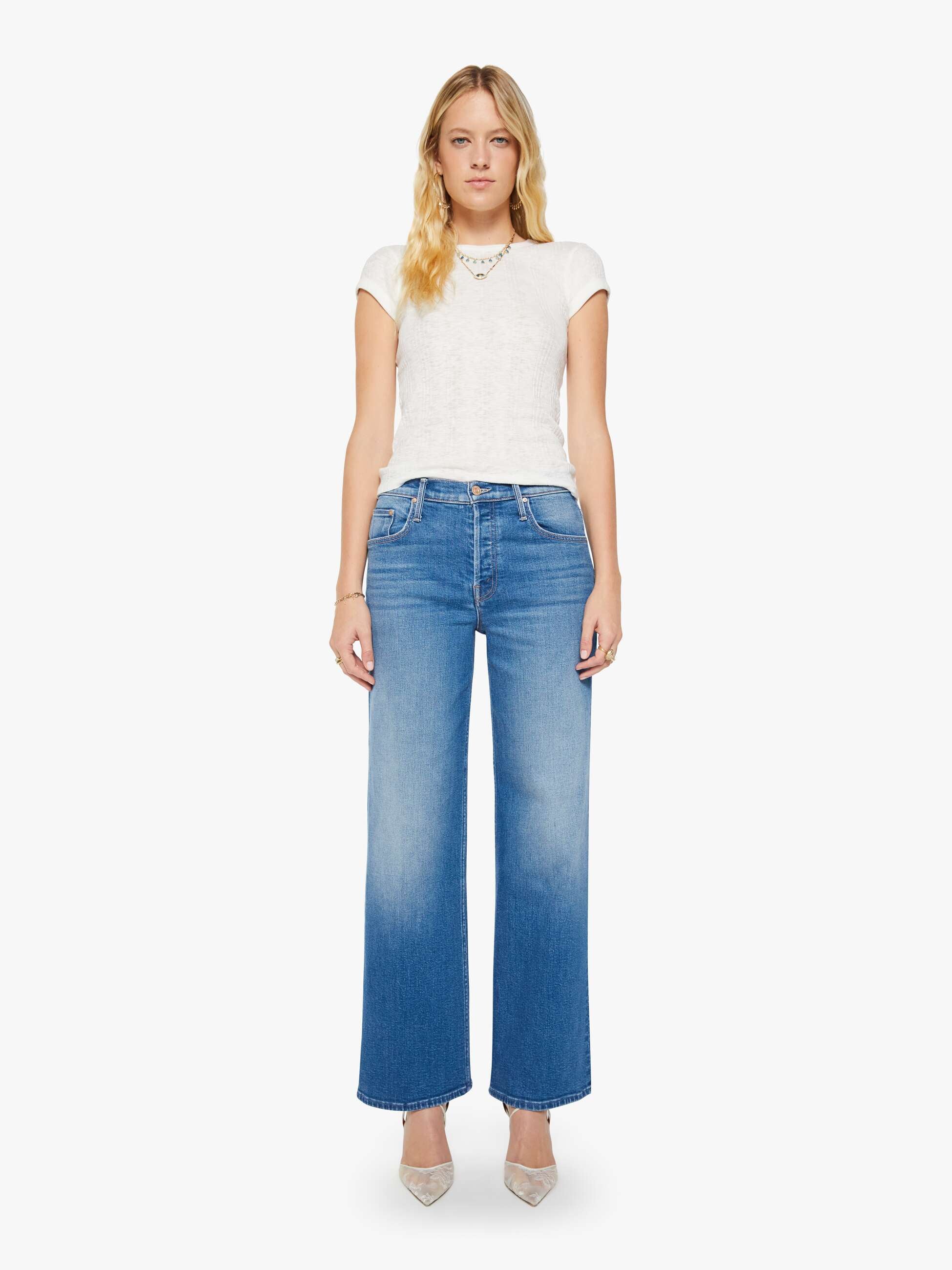 Woman wearing blue jeans and a white top on a white background